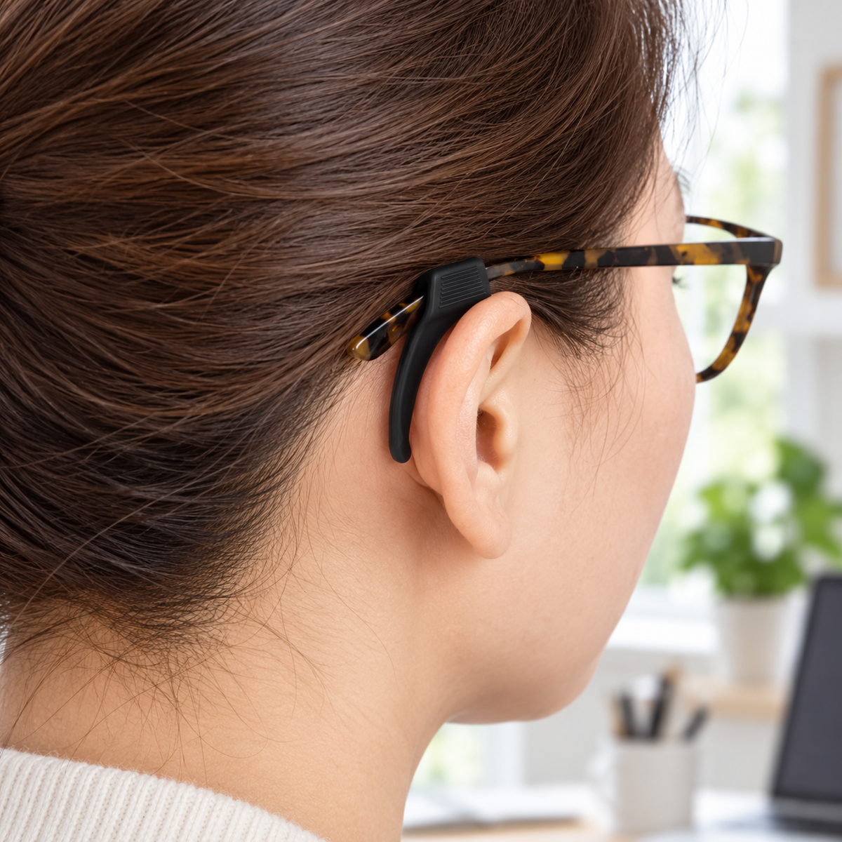 Black silicone ear hook fitted to eyeglasses behind the ear